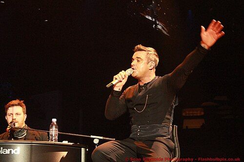 Robbie Williams sorprende a fans con concierto improvisado fuera de su hotel en Lima